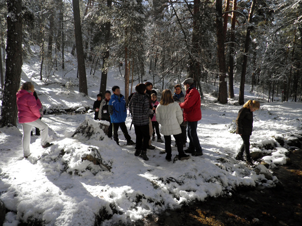 En un paisaje nevado los participantes escuchan al profesor