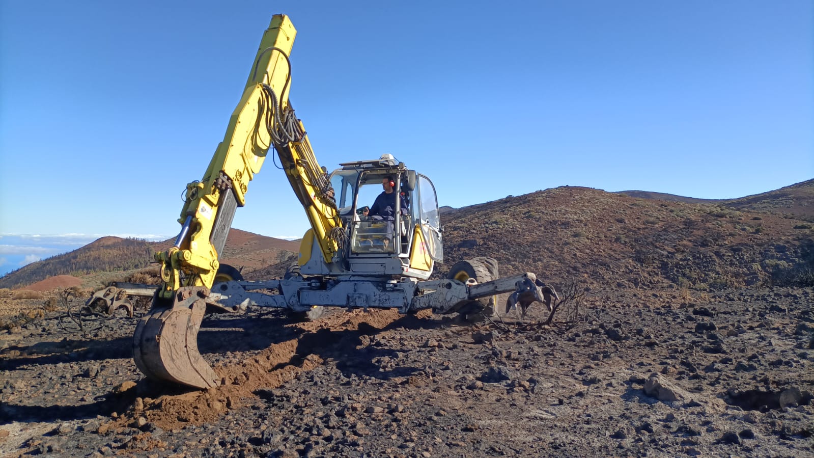 Retroaraña preparando el terreno para la instalación de la valla protectora.